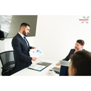 Un groupe d'employés en réunion en train de discuter des données statistiques.